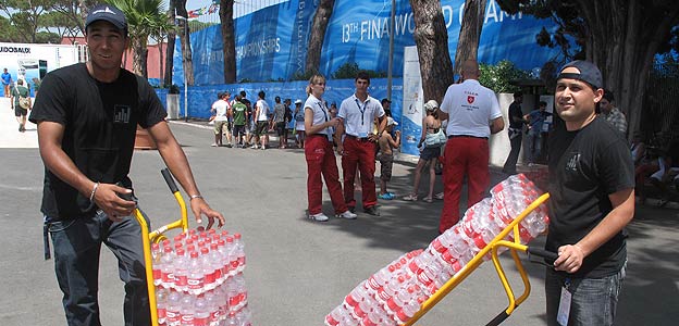 Dos trabajadores distribuyen parte de las 30.00 botellas diarias que se destinan al Foro It&aacute;lico.