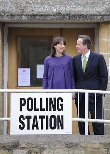 El candidato conservador, David Cameeron, y su mujer, Samantha, abandonan el colegio electoral cerca de Witney en Oxfordshire despu&eacute;s de votar.
