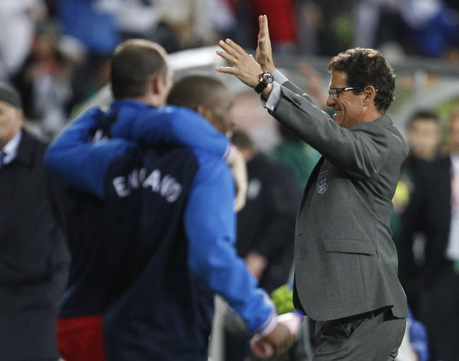 England's coach Fabio Capello celebrates with the team after their 2010 World Cup Group C soccer match against Slovenia in Port Elizabeth
