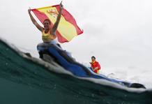 La espa&ntilde;ola Marina Alabau celebra su victoria portando la bandera de Espa&ntilde;a montada en su tabla de windsurf.