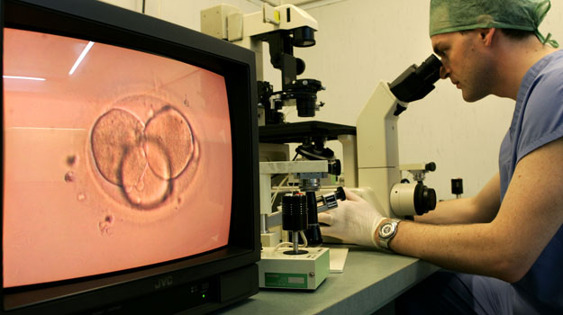 Un científico evalúa una muestra de esperma Un científico evalúa una muestra de esperma