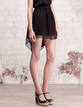 Minifalda asim&eacute;trica y con transparencias de Stradivarius (19,95&euro;)