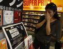 Una fan japonesa entristecida mira un mostrador conmemorativo en una tienda de m&uacute;sica en Tokio.