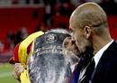 El entrenador del FC Barcelona, Pep Guardiola, besa el trofeo de campe&oacute;n de la Liga de Campeones tras vencer el conjunto azulgrana.