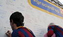 Aficionados de FC Barcelona escriben mensajes de apoyo al t&eacute;cnico cul&eacute;, Pep Guardiola, en un panel instalado en las inmediaciones del Camp Nou