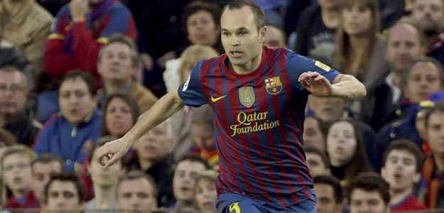 El centrocampista del FC Barcelona Andrés Iniesta elude la entrada del centrocampista alemán del Real Madrid, Sami Khedira