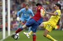Lionel Messi chuta a porter&iacute;a con la oposici&oacute;n del defensa del Villarreal CF Javi Venta.