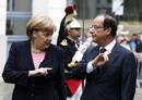 Frances President Hollande listens to Germanys Chancellor Merkel as they attend the 50th anniversary ceremony of a reconciliation meeting in Reims