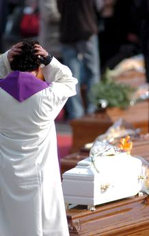 Un sacerdote se emociona ante la visi&oacute;n de un peque&ntilde;o ata&uacute;d en L'Aquila.