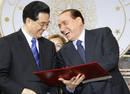 Italys PM Berlusconi holds a document on economic and cultural exchanges with Chinas President Hu in Rome