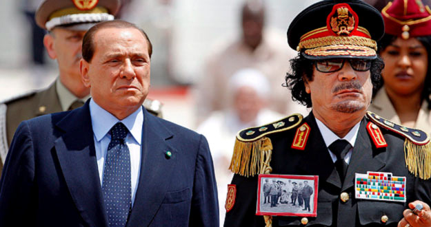 Cuando ha bajado del avi&oacute;n, en donde le estaba esperando Berlusconi, Gadafi llevaba colgada en la chaqueta una foto del l&iacute;der de la resistencia libia anti-italiana.