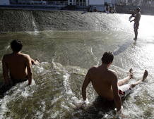 Ni&ntilde;os y mayores se ba&ntilde;an en el rio Arga a su paso por Pamplona en Navarra donde las temperaturas alcanzaban los 39 grados