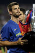 El blaugrana Piqu&eacute; levanta la copa de la Liga obtenida por el Bar&ccedil;a la temporada pasada.