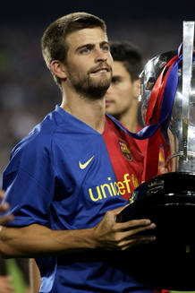 El blaugrana Piqu&eacute; levanta la copa de la Liga obtenida por el Bar&ccedil;a la temporada pasada.