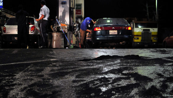 Varias personas permancen en una gasolinera cubierta con ceniza volc&aacute;nica