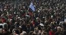 A Greek flag is waved while people take part in an anti-austerity demonstration in Athens