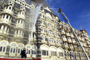 Un grupo de bomberos tratan de apagar el fuego que afecta al hotel Taj