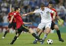 El delantero de la selecci&oacute;n griega Angelos Charisteas lucha un bal&oacute;n ante los jugadores espa&ntilde;oles Andr&eacute;s Iniesta y Ra&uacute;l Albiol.