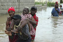 Un grupo de haitianos cruza un r&iacute;o en Puerto Pr&iacute;ncipe