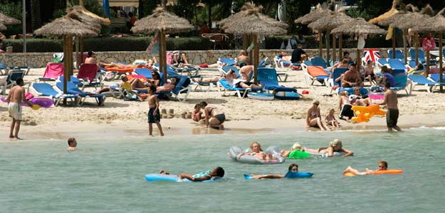 Un grupo de turistas se relaja en la playa en Mallorca