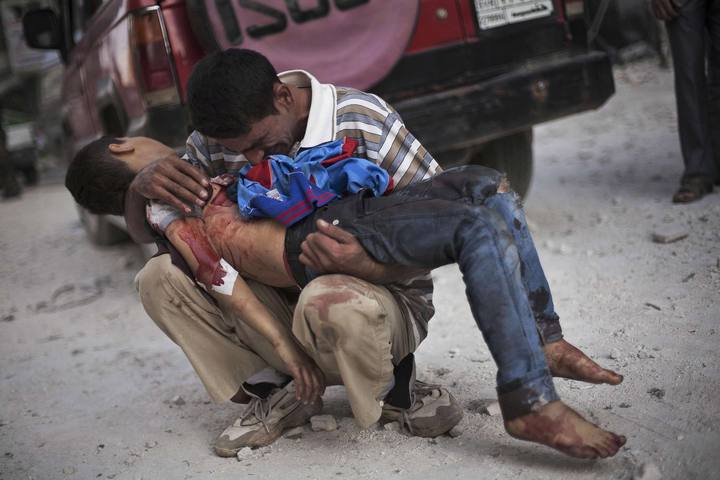 Handout photo of a Syrian man crying while holding the body of his son near Dar El Shifa hospital in Aleppo, Syria