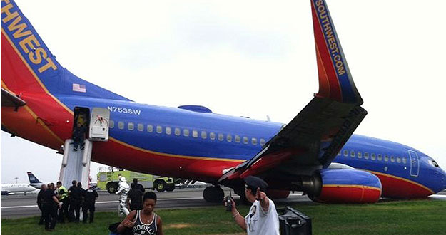 El avión accidentado de la compañía Southwest Airlines se apoya sobre la pista la pista mientras los pasajeros son desembarcados, en el aeropuerto de La Guardia en Nueva York.
