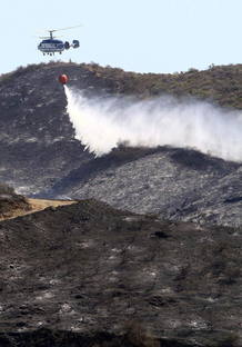 Un helic&oacute;ptero trabaja en las tareas de extinci&oacute;n del incendio forestal