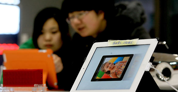 Dos clientes prueban un iPad en una tienda en Dalian, al noreste de China