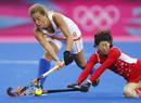 La holandesa Merel de Blaeij y la japonesa Kaori Fujio pelean durante el partido de hockey.