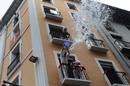 Un hombre arroja agua desde un balc&oacute;n a los asistentes al Chupinazo de los Sanfermines