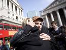 UN HOMBRE CONSUELA A UNA MUJER DURANTE UNA MANIFESTACI&Oacute;N FRENTE AL BANCO DE INGLATERRA