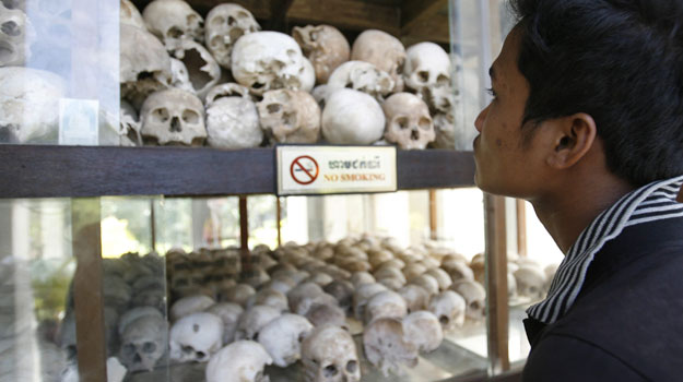Un hombre observa las calaveras de las v&iacute;ctimas del Jemer Rojo en los campos de exterminio de Choeung Ek, a las afueras de Phnom Penh (Camboya)