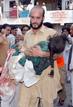 Un hombre transporta a una ni&ntilde;a herida durante la explosi&oacute;n de un coche bomba en un mercado en Peshawar.