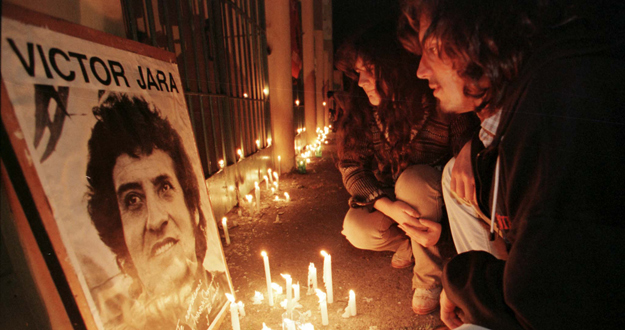 Una pareja rinde homenaje a Victor Jara en las afueras del Estadio Chile de Santiago, donde fue asesinado.