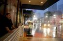 Un hombre observa la lluvia desde la entrada del hotel Ritz Carlton despu&eacute;s de que el hurac&aacute;n 