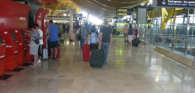 Dos pasajeros se dirigen hacia el mostrador de facturaci&oacute;n en Barajas