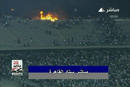In this still image taken from video, soccer fans run near a fire at the stop of the stadium during a soccer match between Al Ahli and al-Masry in Port Said