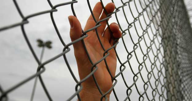An inmate serving a jail sentence rests his hand on a fence at Maricopa County's Tent City jail in Phoenix An inmate serving a jail sentence rests his hand on a fence at Maricopa County's Tent City jail in Phoenix
