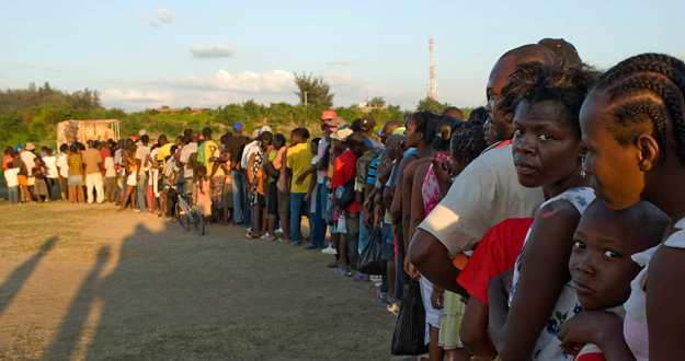 Desplazados hatianos hacen cola en un punto de distribuci&oacute;n de la ONU.