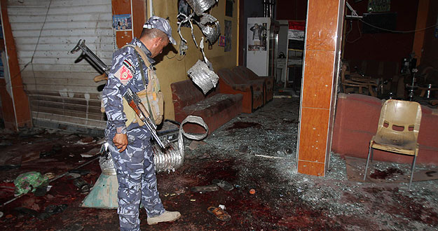 Un policía inspecciona el lugar del atentado con bomba en un café en Kirkuk, a 250 kilómetros al norte de Bagdad, en el que han muerto al menos 38 personas según la policía y lo médicos. La explosión ha tenido lugar en una cafetería donde se habían