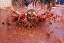 Un j&oacute;ven nada en un aut&eacute;ntico r&iacute;o de tomate en Bu&ntilde;ol (Valencia) durante la tradicional Tomatina