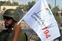 Un joven palestino ondea ante un soldado israel&iacute; una bandera con el lema del reconocimiento de Palestina como el estado 194 de la ONU