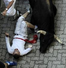 Uno de los morlacos arrolla a un mozo a la entrada al callej&oacute;n.