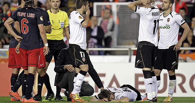 Los jugadores del Valencia CF reaccionan ante la lesión de su compañero Canales (en el suelo) durante el partido de vuelta de semifinales de la Liga Europa jugado ante el Atlético de Madrid.