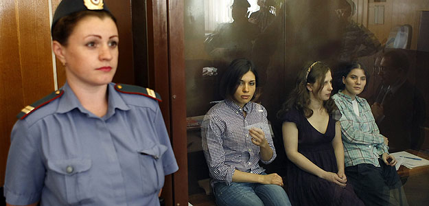 Las tres integrantes del grupo Pussy Riot acusadas de gamberrismo permanecen en una sala acristalada durante la vista del juicio