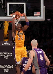 Kobe Bryant machaca la canasta de los Suns en presencia de los jugadores Grant Hill y Marcin Gortat.