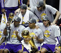 Kobe Bryant muestra la copa de campeones a sus compa&ntilde;eros en la foto de grupo del equipo vencedor.