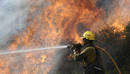 A firefighter aims water at the Station Fire in Angeles National Forest above the La Canada Flintridge area of Los Angeles
