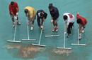 Varios empleados del Torneo retiran el agua acumulada en las lonas que protegen las pistas, durante la tercera jornada del Torneo Internacional de Tenis Roland Garros de Par&iacute;s en la que la lluvia ha sido la protagonista.