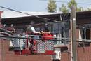 Law enforcement officers use a fire truck lift to inspect the apartment where suspect James Eagan Holmes lived in Aurora